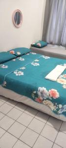 ein Bett mit einer blauen Decke mit Blumen drauf in der Unterkunft PD Seaview Corus Paradise Lagoon in Port Dickson + 59 Fotos