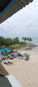 einen Strand mit Autos auf dem Sand und Palmen in der Unterkunft PD Seaview Corus Paradise Lagoon in Port Dickson