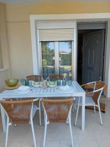 a white table with chairs and a table with bowls on it at Villa Danai Nefeli Siviri in Siviri +11 photos