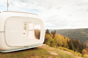 una vista desde la parte trasera de un vehículo blanco en una colina en Zwischen Baumwipfeln träumen, einzigartiges Naturerlebnis, en Bad Wildbad