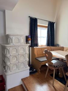 a room with a table and a desk and a table and chair at Cèsa Emily in Campitello di Fassa