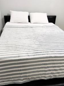 1 cama blanca y negra con 2 almohadas en Posada Sebastian, en Valencia