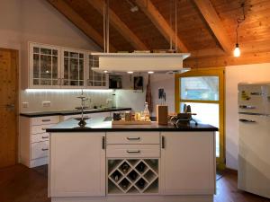 a kitchen with white cabinets and a white refrigerator at Gut Müllerleile Ferienhaus in Gengenbach