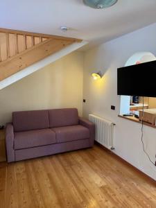a living room with a couch and a staircase at Cèsa Emily in Campitello di Fassa