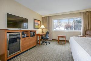 a hotel room with a bed and a flat screen tv at C'mon Inn Missoula in Missoula