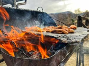 a grill with some food on it with flames at Complex Chalet -Turlashkata Kushta in Gabrovo