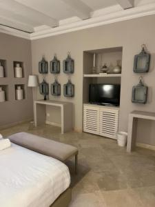 a bedroom with a bed and a flat screen tv at Relais Corte Degli Aragonesi in Ischia