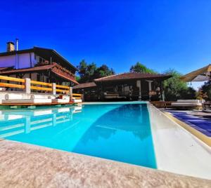 a large swimming pool with chairs in front of a house at Complex Chalet -Turlashkata Kushta in Gabrovo