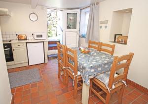 eine Küche mit einem Tisch und Stühlen in einer Küche in der Unterkunft Hafan Cottage in Caernarfon