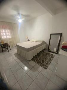 a bedroom with a bed and a mirror on the floor at Casa Marinho in São Pedro da Aldeia