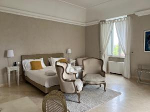 a bedroom with a bed and a chair at Relais Corte Degli Aragonesi in Ischia