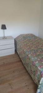 a bedroom with a bed and a dresser with a bedspread with flowers at House with garden in Marinha da Mendiga in Casais do Chão da Mendiga +20 photos