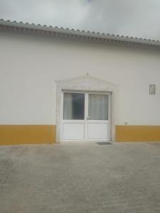 a white building with a door with a window at House with garden in Marinha da Mendiga in Casais do Chão da Mendiga
