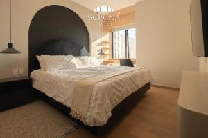 a bedroom with a bed with a large headboard at Elegant Condo with Air Conditioning, Pool, Sauna, & Fitness Center in Polanco in Mexico City +36 photos