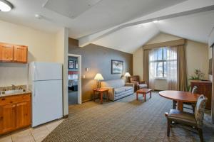 a kitchen and living room with a white refrigerator at C'mon Inn Missoula in Missoula