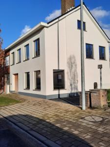 Un edificio bianco con un palo davanti di Dea a Izegem