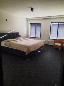 una camera da letto con un letto grande e una sedia di Dea a Izegem