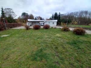a house with a grassy yard in front of a house at Pensjonat Motylewo in Bogdaniec +2 photos