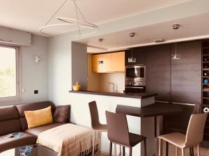 ein Wohnzimmer mit Couch und Küche in der Unterkunft Bel appartement vue mer in Royan