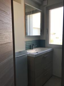 ein Badezimmer mit Waschbecken und Spiegel in der Unterkunft Bel appartement vue mer in Royan
