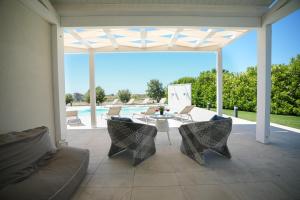 a patio with a table and chairs and a pool at Villa Aria - Modica in Modica +46 photos