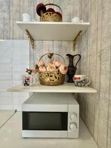 a microwave on a shelf with a basket on it at ApartPoltava Смак Італії у самому центрі Полтави , білосніжна студія в новобудові, банківський чек in Poltava