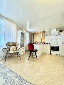 a large kitchen with a red chair and a table at ApartPoltava Смак Італії у самому центрі Полтави , білосніжна студія в новобудові, банківський чек in Poltava