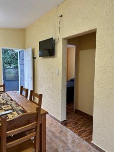 a dining room with a table and a tv on the wall at La casita de Oli in Tanti