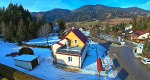 una piccola casa nella neve in una città di Villa Edelweiss Stuhleck a Spital am Semmering