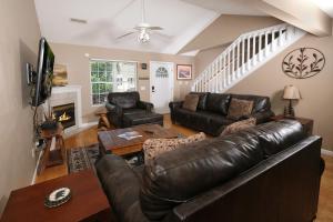 a living room with a leather couch and a fireplace at Conveniently located in Pigeon Forge, spacious & clean 3 bedroom! in Pigeon Forge