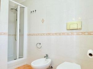 een witte badkamer met een toilet en een wastafel bij Appartamento Spiga in San Vincenzo +6 foto's