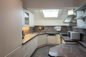 a kitchen with white cabinets and a skylight at Chiemgauzeit Ferienwohnung - Chiemgau Karte in Inzell