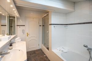 a bathroom with a tub and a sink and a shower at Chiemgauzeit Ferienwohnung - Chiemgau Karte in Inzell +5 photos
