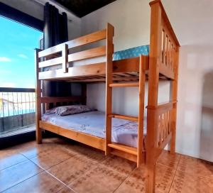 a bedroom with bunk beds in a room with a window at Pousada do Nestor in São Gabriel