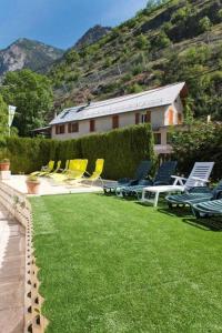 un gruppo di sedie sedute su un prato con una casa di Camping 5 étoiles - Piscine - eeceff a Le Bourg-dʼOisans