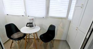 a kitchen with two black chairs and a blender on a table at Apartament Victoriei - Centru in Bucharest