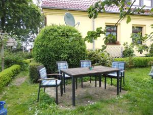 a table and chairs in front of a house at Ferienwohnung "Tier-Garten" in Tribsees
