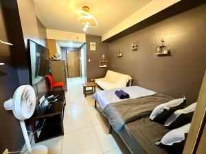 a bedroom with a bed and a room with a fan at Kathys Crib Family Suite Room at Shell Residence in Manila +37 photos