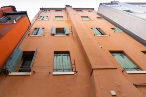 a tall orange building with many windows on it at Girasole in Chioggia
