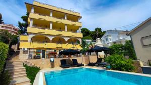 a hotel with a swimming pool in front of a building at Villa Penava, private beach, pool and 7min to Trogir in Trogir