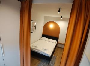 a small bed in a small room with an orange curtain at Christians Haus in Târgu-Mureş