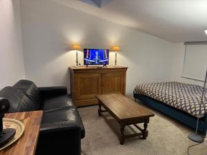 ein Wohnzimmer mit einer Couch und einem Bett in der Unterkunft Petite maison indépendante avec parking in Vétheuil