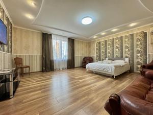 a bedroom with a bed and a couch at ApartPoltava 100 квадратних метрів затишку в серці Полтави, Корпусний парк, Банківський ЧЕК in Poltava