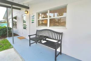 a bench sitting on the side of a house at Jensen Surf Shack in Jensen Beach
