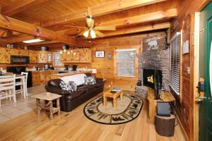 a living room with a couch and a fireplace in a cabin at 1BR-hot tub-pool table-close to Dollywood 1 free ticket! in Sevierville