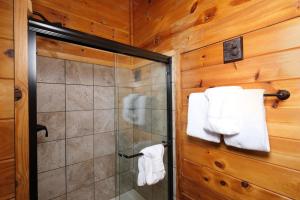 a bathroom with a shower and towels on a wall at 1BR-hot tub-pool table-close to Dollywood 1 free ticket! in Sevierville
