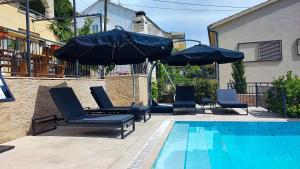 a swimming pool with chairs and umbrellas next to a swimming pool at Villa Penava, private beach, pool and 7min to Trogir in Trogir