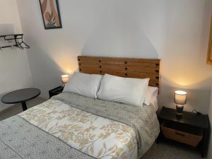 a bedroom with a bed and a table and two lamps at Habitación independiente 2 en casa particular in Utrera +5 photos
