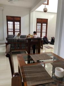 two people sitting on a couch with a dog at Lanka villa mirissa private villa 6bedrooms in Mirissa