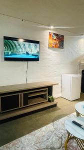 Una sala de estar con un televisor de pantalla plana en la pared. en The Beverly by maboneng, en Johannesburgo